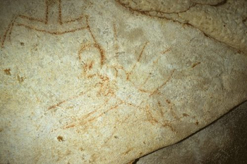 Cave painting of human figure with large head and eyes