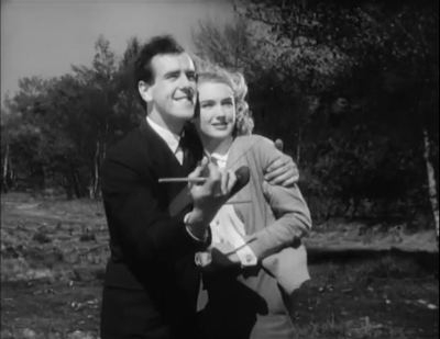 man and woman hugging whilst flying a kite